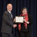 Doctor Potteiger psoing for a photo with an award recipient in a black top and red scarf